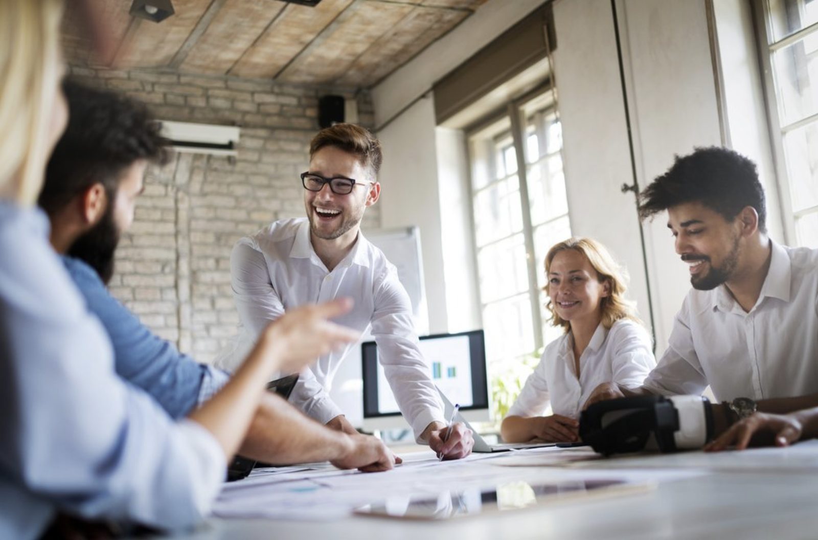 A man leading a meeting and speaking fluently with colleagues